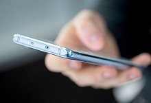 Ein Handy liegt in einer Hand - Foto: Andrea Warnecke/dpa-tmn