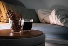 Aufgeschlagenes Bett mit Salzstangen und Cola - Christin Klose/dpa-tmn