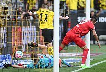 Dortmunds Marco Reus (M) stochert den Ball gegen Leverkusens Torwart Lukas Hradecky (l) und Piero Hincapie &uuml;ber die Linie. - Bernd Thissen/dpa