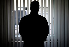 Ein Mann blickt aus einem Fenster - Daniel Karmann/dpa