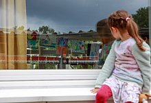 Ein M&auml;dchen sitzt auf einer Fensterbank - Mascha Brichta/dpa-tmn