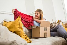 Eine Frau packt Klamotten aus - Christin Klose/dpa-tmn