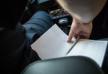 Ein Mann f&uuml;hrt ein Fahrtenbuch im Auto - Christin Klose/dpa-tmn