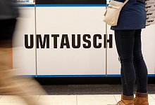 Eine Frau steht vor einem Schild mit der Aufschrift "Umtausch" - Roland Weihrauch/dpa/dpa-tmn