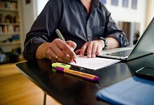 Mann arbeitet im Homeoffice an seinem Schreibtisch - Finn Winkler/dpa/dpa-tmn