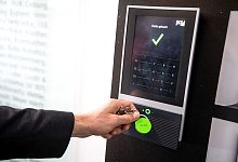 Ein Mitarbeiter erfasst seine Arbeitszeit an einem Terminal - Sina Schuldt/dpa