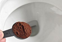 Löffel Kaffeesatz ist über einer Toilette zu sehen - Till Simon Nagel/dpa-tmn