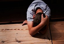 Kind versteckt sein Gesicht unter seinen Armen - Annette Riedl/dpa/dpa-tmn