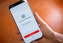 Eine Frau nutzt eine Handy-App zum Sparen - Nico Tapia/dpa-tmn