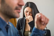 Frau schaut niedergeschlagen w&auml;hrend eines Gespr&auml;chs mit Kollegen - Christin Klose/dpa-tmn