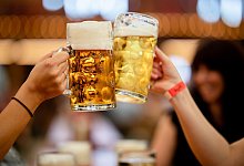 Besucher des Stuttgarter Frühlingsfests stossen mit 2 Maß Bier an - Christoph Schmidt/dpa/dpa-tmn