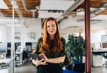 Ein Frau mit Tablet in einem Gro&szlig;raumb&uuml;ro - Zacharie Scheurer/dpa-tmn