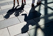 Zwillingsschwestern mit ihrer Großmutter im Gegenlicht. Großeltern spielen nach wie vor eine wichtige Rolle in der Kinderbetreuung. - Julian Stratenschulte/dpa