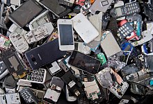 Alte Handys und Smartphones liegen in einem Container - Julian Stratenschulte/dpa/dpa-tmn