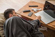 Ein Mann mit Erkltung bedient ein Laptop - Christin Klose/dpa-tmn