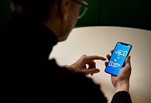 Ein Mann verwendet ein Smartphone zum Geldverkehr - Zacharie Scheurer/dpa-tmn