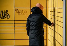 Eine Frau holt ein Paket bei einer Packstation ab - Zacharie Scheurer/dpa-tmn