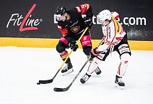 Tobias Eder (l) und der Schweizer Calvin Th&uuml;rkauf im Zweikampf um den Puck. - Matthias Balk/dpa