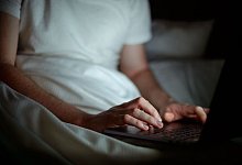 Ein Mann arbeitet im Batt am Laptop - Sina Schuldt/dpa/dpa-tmn