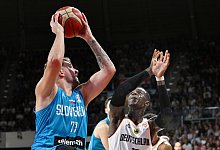 Deutschlands Dennis Schröder (r) in Aktion gegen Sloweniens Luka Doncic. - Angelika Warmuth/dpa