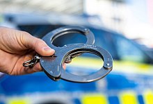 Handschellen vor Polizeiwagen - David Inderlied/dpa