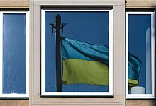 Eine Fahne der Ukraine spiegelt sich in einem Fenster - Robert Michael/dpa-Zentralbild/dpa-tmn