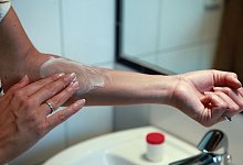 Frau cremt Arm mit einer Salbe ein - Silvia Marks/dpa-tmn