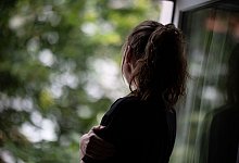 Frau am Fenster - Fabian Sommer/dpa/Symbolbild