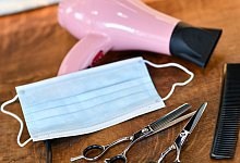 Friseurscheren und Kamm liegen neben Maske und Haartrockner. - Foto: Kirsten Neumann/dpa-tmn