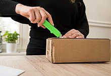 Frau &ouml;ffnet ein Paket - Christin Klose/dpa-tmn