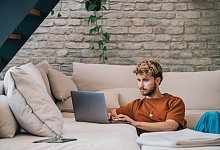 Ein junger Mann arbeitet am Laptop - Zacharie Scheurer/dpa-tmn