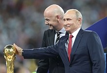 Die letzte WM 2018 richtete als Gastgeber Russland aus. Wladimir Putin steht neben FIFA-Pr&auml;sident Gianni Infantino am WM-Pokal. - Cao Can/xinhua/dpa