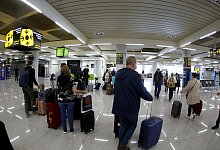 FILE PHOTO: Passengers wearing protective face masks arrive at Son Sant Joan airport in Palma de Mallorca - Reuters