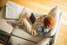Eine Frau mit Tablet im Wohnzimmer - Christin Klose/dpa-tmn