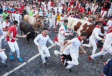 Wei&szlig; gekleidete junge M&auml;nner mit roten Halst&uuml;chen laufen beim &laquo;Sanfermines&raquo;-Fest bei der Stierhatz mit den Tieren. - Eduardo Sanz/EUROPA PRESS/dpa