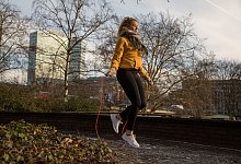 Eine Frau trainiert mit einem Springseil - Christin Klose/dpa-tmn