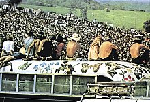 Woodstock-Festivalbesucher haben das Dach eines der bemalten ehemaligen Schulbusse der &bdquo;Hog Farm&ldquo;-Kommune erklommen. - imago images