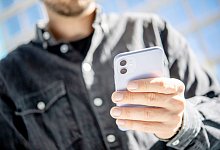 Ein Mann hält ein Smartphone in der Hand - Zacharie Scheurer/dpa-tmn