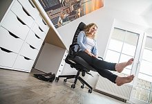 Eine Frau sitzt mit gestreckten Beinen auf einem Bürostuhl - Christin Klose/dpa-tmn