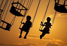 Zwei Kinder in einem Kettenkarussell - Sebastian Kahnert/dpa/dpa-tmn