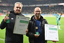 Werders Stadionsprecher Arndt Zeigler (l) und Mario Wiggert mit der Fair-Play-Medaille. - Carmen Jaspersen/dpa