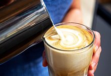 Milch wird in einen Kaffee gegossen - Bernd Diekjobst/dpa-tmn