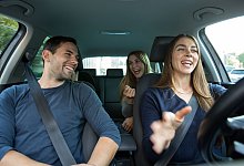 Drei Leute sitzen ausgelassen in einem Auto - Christin Klose/dpa-tmn