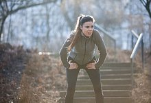 Frau macht während des Lauftrainings eine Pause - Christin Klose/dpa-tmn