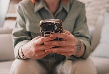 Eine junge Frau tippt auf ihrem Smartphone - Zacharie Scheurer/dpa-tmn