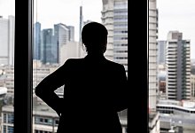 Frau schaut aus einem Bürofenster - Hannes P Albert/dpa/dpa-tmn