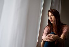 Frau schaut aus Fenster - Franziska Gabbert/dpa-tmn