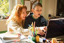 Mutter und Sohn sitzen gemeinsam vor einem Laptop - Christin Klose/dpa-tmn