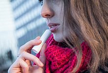 Eine Frau trägt Lippenbalsam auf - Christin Klose/dpa-tmn