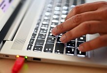 Laptop mit Netzwerkkabel - Uli Deck/dpa